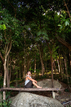 guy is meditating while sitting in the jungle in nature, concentration and calmness