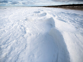 Obraz premium Frozen sea with snow and shoreline. Abstract snow formations.