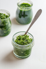 Pesto sauce in three jars on a white background