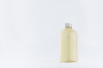 Transparent plastic low thick bottle with pale fresh drink or cosmetic essential oil with silver cap mockup on white background, template, copy space.