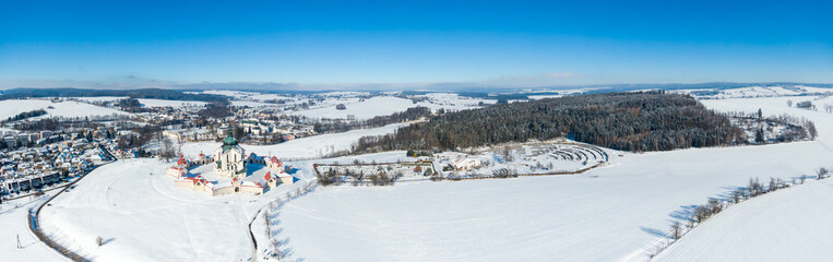 Aerial drone view of Pilgrimage Church of Saint John of Nepomuk, Zdar nad Sazavou, Czech Republic. UNESCO heritage. Ancient monastery at Zelena Hora hill. Winter weather with snow, blue sky.