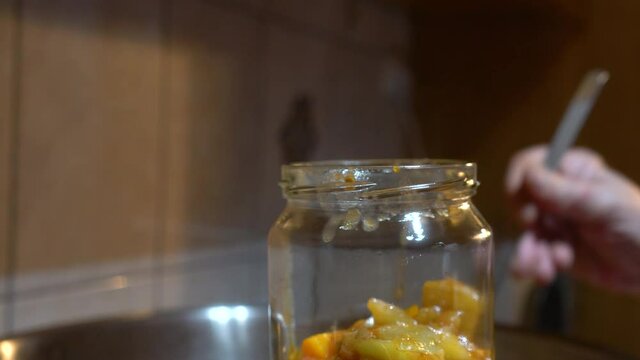 Pouring homemade mixed vegetable (G&uuml;ve&ccedil;) into sterile jars - (4K)