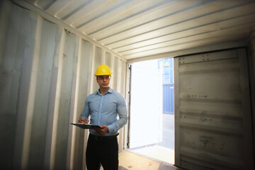 Foreman control loading Containers box from Cargo freight ship for import export.