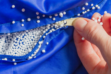 Open the zipper of the blue chair bag to add new filler, the balls stick to your hands