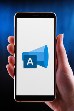 Hand holding smartphone displaying logo of Microsoft Advertisin