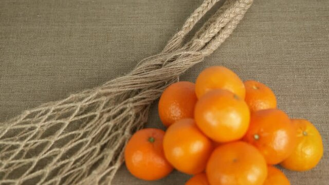 Tropical fruits in bag. Tangerines from a string bag.