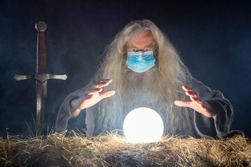 Wizard with coronavirus mask looking in magic ball to see future