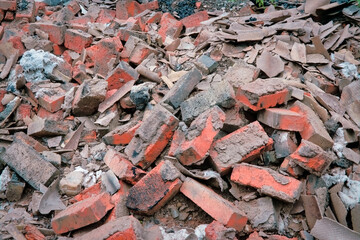 Heap of broken old red brick close-up. Red brick texture.