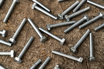 Stainless bolts on wooden background