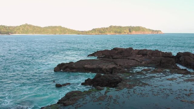 Rock beach landscape view. Taken from drone flying backward slowly