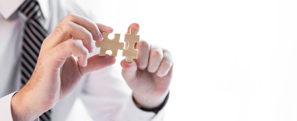 Businessman hand connecting jigsaw puzzle.Business solutions, success and strategy concept.