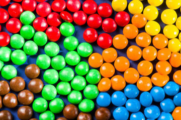 M&M's candy on the blue background, colorful candy, multicolored gradient