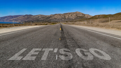 Let's Go written on highway road to the mountain