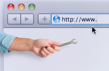 Hand with wrench over a internet web browser. concept of fix errors