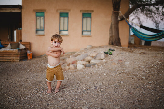 A young boy standing in the desert looking forward