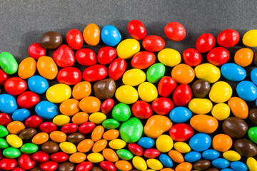M&M's candy on the black background, colorful candy, multicolored gradient