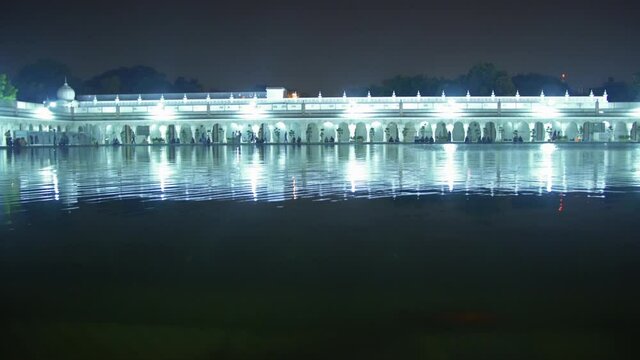 Beautiful Indian Temple With Evening Lights Reflected On Lake In Delhi, India - Wide Shot