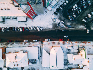 Aerial top down view of road in small european city with snow covered roofs