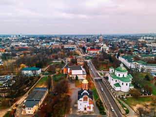 Fototapeta na wymiar Aerial view of two old churches near river and bridge in small european city