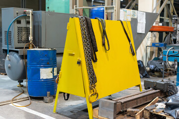 Production chains with hooks hang on a stand in the workshop at the factory.