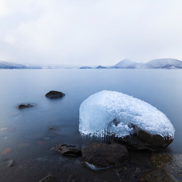 Long exposure shot of rock covered in ice at lake Toya, Hokkaido, Japan