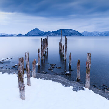 Long exposure shot of wooden sticks in the water at lake Toya, Hokkaido, Japan