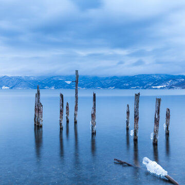 Long exposure shot of wooden sticks in the water at lake Toya, Hokkaido, Japan