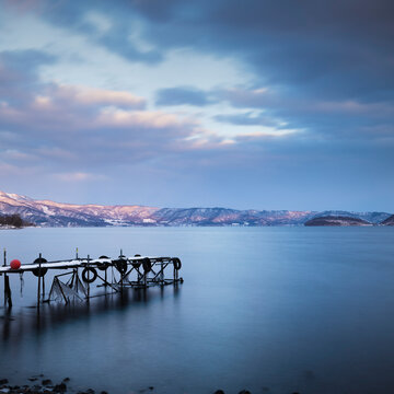 Long exposure shot of boat pier in winter at lake Toya, Hokkaido, Japan