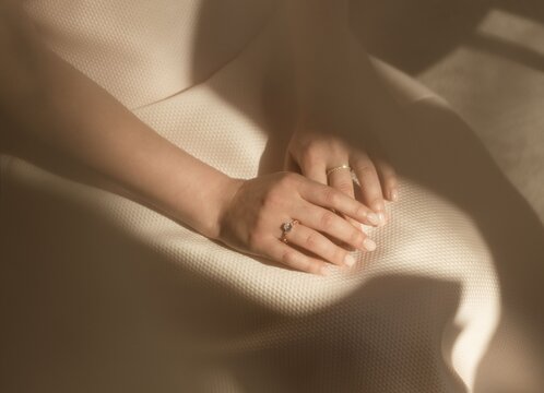 Female hands with rings crossed on lap