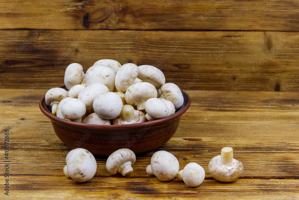 Sticker Fresh champignon mushrooms in ceramic bowl on the wooden table