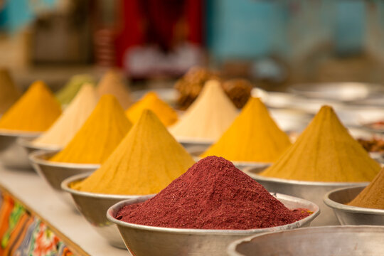 Silver bowls filled with turmeric and sumac in a spice bazaar