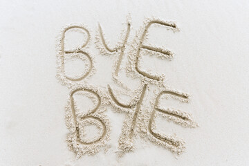 Bye Bye written in sand on white beach