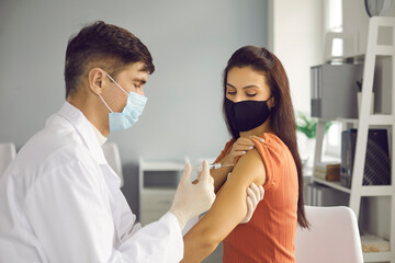 Disease prevention, immunization and vaccination campaign concept. Doctor giving a flu injection to...