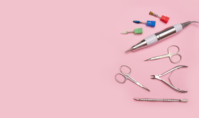 Nail tool. Professional steel manicure and pedicure tools. Manicure scissors, tongs, cutter, clipper and nozzles for polishing nails on a pink background.