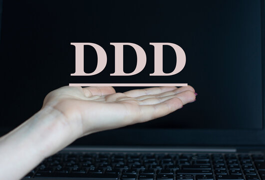 DDD - acronym on a woman's hand against the background of a laptop