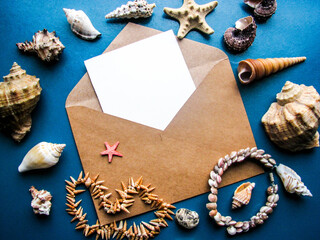 postcard mockup. blank white card with kraft brown paper envelope and seashells   