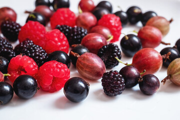Assorted berries of raspberries, gooseberries, currants on a white background