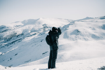 Adventure photographer taking a photo on a snowy mountain. © Luis