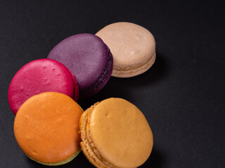 macaroons on a black background, sweet and colorful dessert. Cook at home. Photo for printing industry, confectioners. High quality photo
