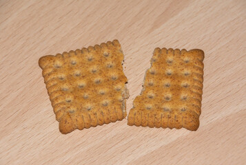 a biscuit broken into two pieces on a wooden board