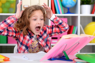 Cute teen girl doing homework in her room