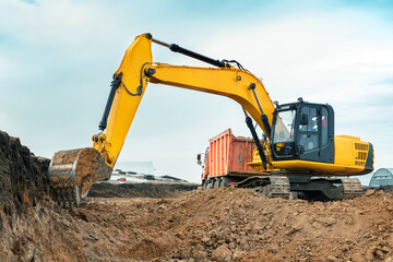 A large construction excavator of yellow color on the construction site in a quarry for quarrying....