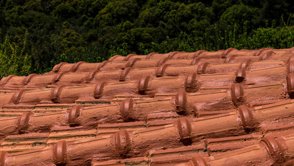 Closeup of the red clay roof tiles painted with water-repellent paint