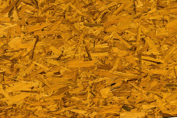 Yellow wood chipboard can use as background. Close-up of pressboard texture.