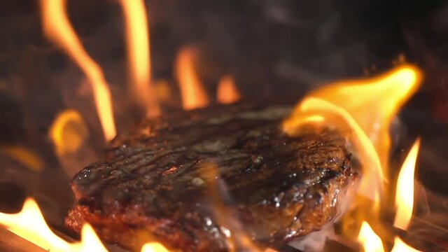 A lot of meat is grilled, covered with fire