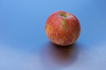 natural ripe minimalist apple and reflection on blue clean metallic background
