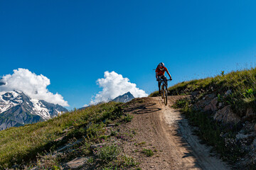 Rider Jump on mountain bike downhill track, les 2 alpes, ecrins, oisans, france