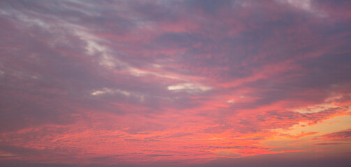 Naklejka na ściany i meble Purple-pink sunset in the sky, clouds. Summer time. Background, copyspace