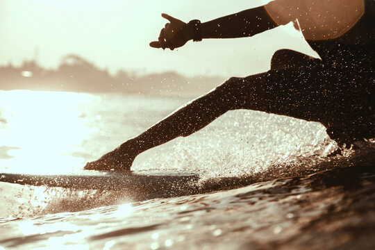 Surfer in ocean at sunrise
