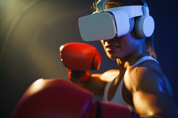 Medium close up shot of Asian woman wearing VR headset to exercise with simulation boxing games, Young female athlete boxer with virtual reality combat experience activity.